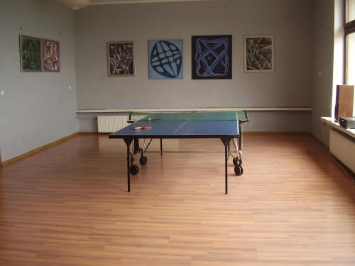 a ping pong table in a room with paintings at Dom Wypoczynkowy POD FORTAMI in Srebrna Góra