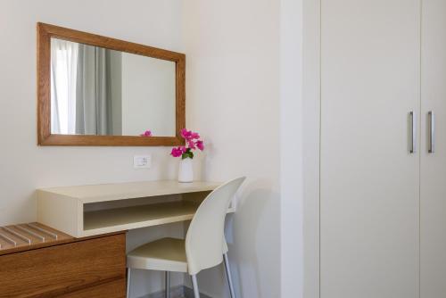 a white desk with a mirror and a white chair at Despina Apartments in Plataniás