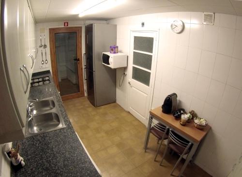 a small kitchen with a table and a refrigerator at FINCA CAL TARRÉ - Alojamientos turísticos in Campdevánol