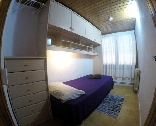 a small bedroom with a bed and a dresser at FINCA CAL TARRÉ - Alojamientos turísticos in Campdevánol