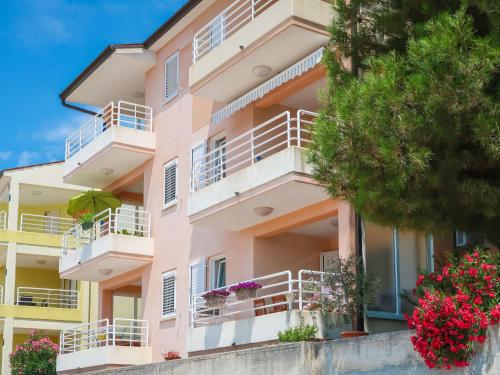 a pink apartment building with flowers on balconies at Apartment Egle by Interhome in Rabac
