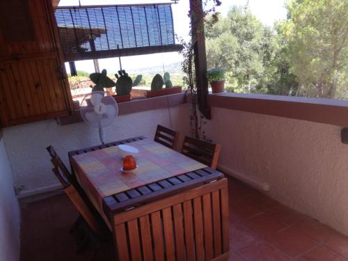 ein Tisch und Stühle in einem Zimmer mit Fenster in der Unterkunft Lucianasit in Cugnana Verde
