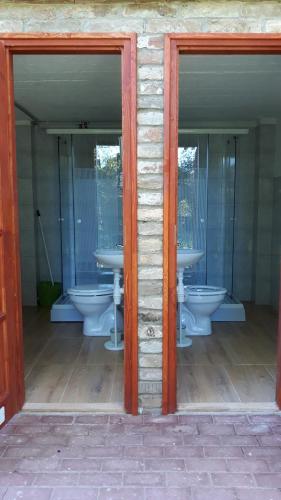 a bathroom with two sinks and two toilets at Víziszony Nyaraló Gerendaház in Mindszent