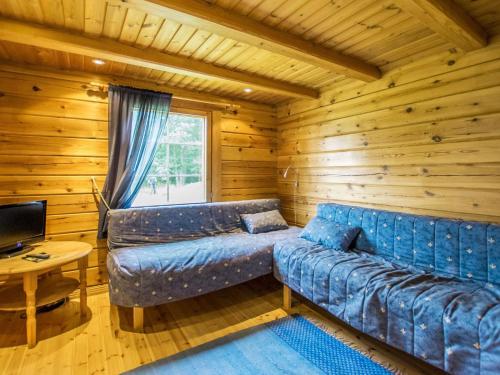 un soggiorno con divano in una baita di tronchi di Holiday Home Meripoika by Interhome a Heinjoki