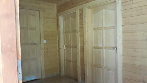 two closets in a room with wooden walls at Víziszony Nyaraló Gerendaház in Mindszent