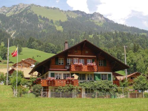 ein Haus auf einem Feld mit einer Flagge davor in der Unterkunft Apartment Bärgfriede by Interhome in Oberwil