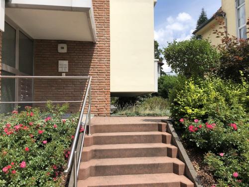 a set of stairs in front of a building with flowers at Appartement an der Helenenquelle in Bad Pyrmont