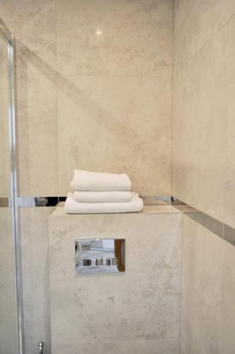 a shower with three towels on a counter in a bathroom at Kamienica House 9 in Wągrowiec