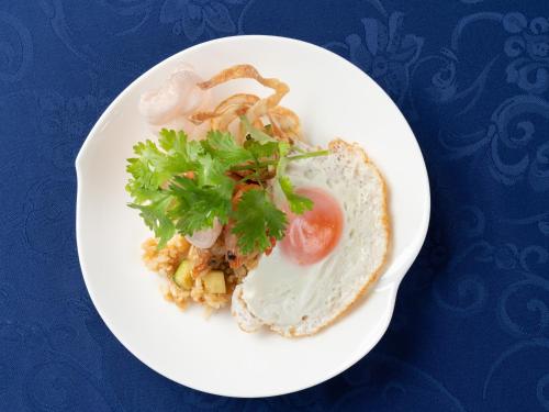 a white plate of food with an egg and lettuce at Garden Terrace Fukuoka in Fukuoka