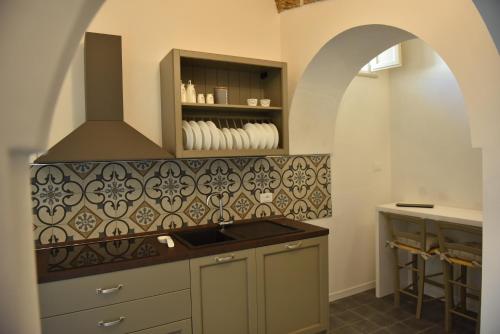 a kitchen with an archway and a stove top oven at Tobacco Suite in Mesagne