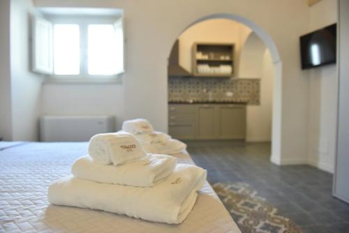 three stacks of towels sitting on top of a bed at Tobacco Suite in Mesagne
