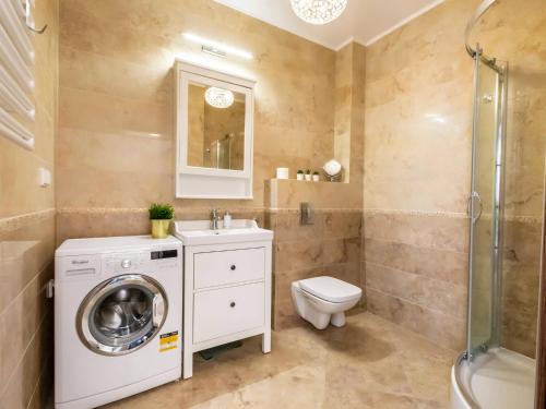 a bathroom with a washing machine and a toilet at VacationClub – Diune Apartament 60 in Kołobrzeg