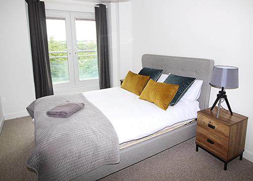 a bedroom with a bed with yellow pillows and a window at The Elm @ Short Stays in Basingstoke