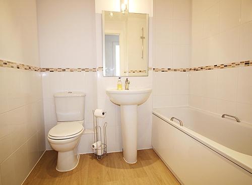 a bathroom with a toilet and a sink and a tub at The Elm @ Short Stays in Basingstoke