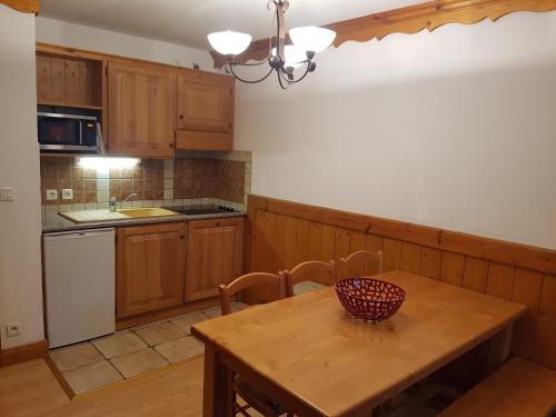 a kitchen with a wooden table with a bowl on it at Appartement Le Pic Blanc in Oz