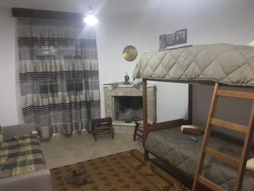 a bedroom with a bunk bed and a fireplace at Dimitris house in Kalabaka