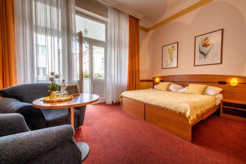 a hotel room with a large bed and a large window at Hotel Arcus Garden in Bratislava
