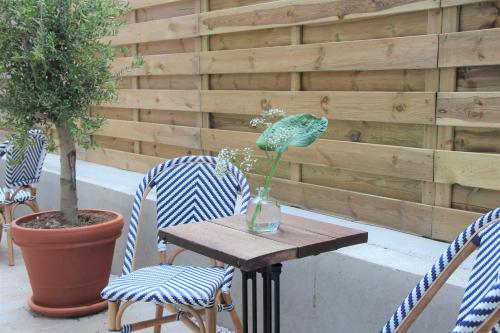 a table with two chairs and a vase with a flower on it at Hotel Paradis Zandvoort in Zandvoort