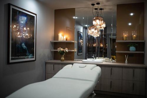 a bathroom with a bed and a sink with lights at Hotel Nadmorski in Łeba