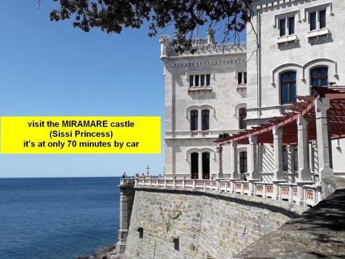 a building next to the ocean with a yellow sign at Cristallo Sea View in Lignano Sabbiadoro