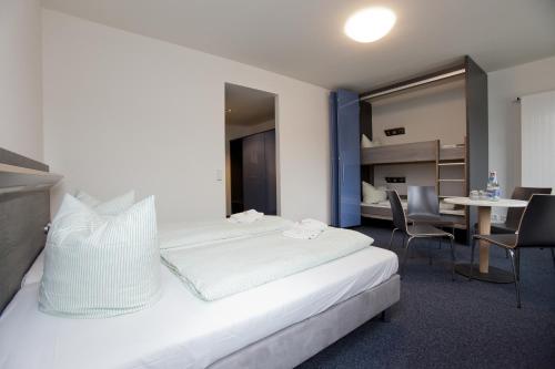 a hotel room with a bed and a table and chairs at Jugendherberge Duisburg Sportpark in Duisburg