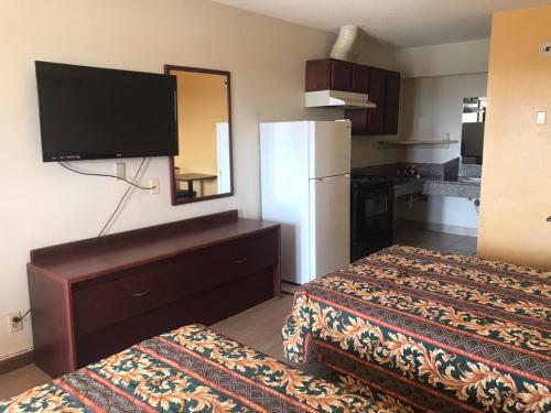 a hotel room with two beds and a refrigerator at Lone Star Inn in Carrollton