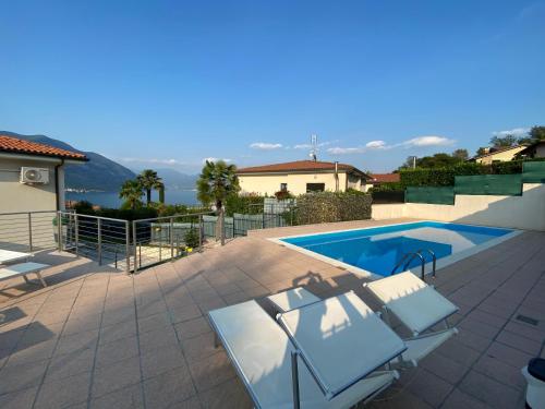 - une piscine avec 2 chaises longues à côté d'une maison dans l'établissement B&B Panorama Iseo, à Iseo