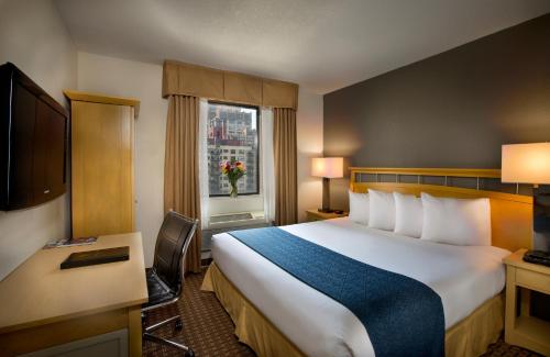 um quarto de hotel com uma cama grande e uma janela em Hudson River Hotel em Nova York
