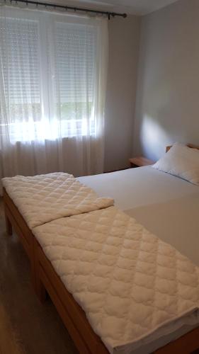 a bed in a bedroom with a window at Apartmani V&F in Vrnjačka Banja