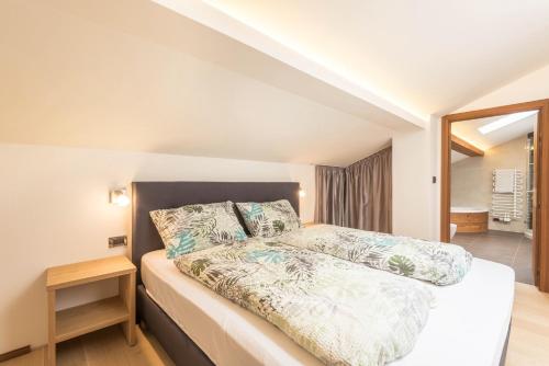 una camera da letto con un letto e uno specchio di Apt Hetti - Haus Kostner a Santa Cristina in Val Gardena