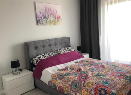 Un dormitorio con una cama con una colcha colorida encima. en GARDENIA Apartament Przy Plaży 19, en Dziwnów