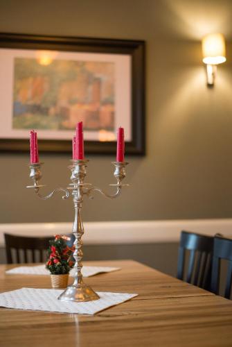 a candle holder on a table with two pink candles at Vila Emilia in Vrnjačka Banja