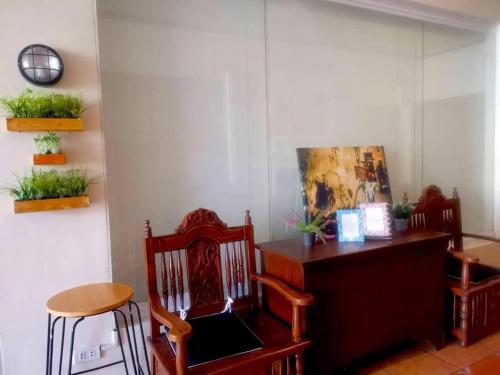 um quarto com duas cadeiras e uma mesa com plantas em The Stopover Hostel - Mactan em Mactan