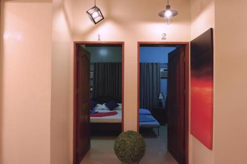 a room with two doors and a bedroom with a bed at The Stopover Hostel - Mactan in Mactan