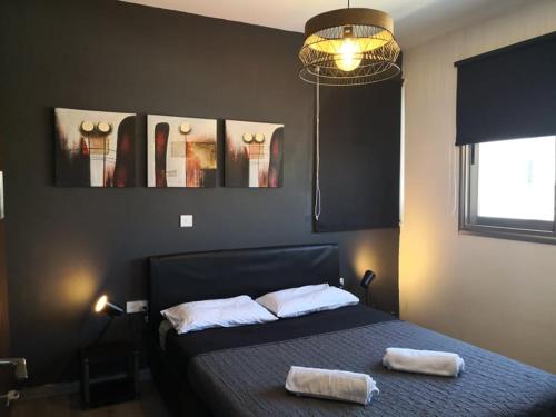 1 dormitorio con 1 cama con 2 toallas en Loizou Holdings Flat 301, en Lárnaca
