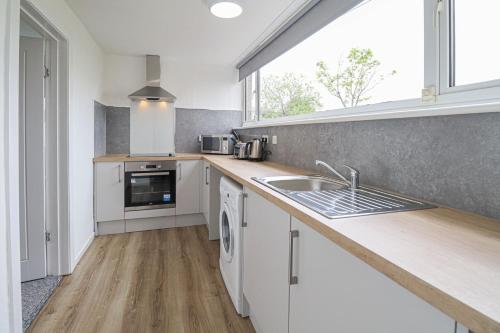 uma cozinha com um lavatório e uma bancada em Trinidad House em East Kilbride