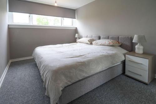 Un dormitorio con una cama grande y una ventana en Trinidad House en East Kilbride