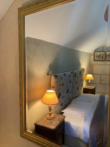 a picture of a bedroom with a bed and a lamp at Chambres d'Hôtes Le Clos des 3 Rois in Thouarcé