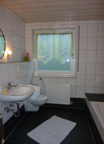 a bathroom with a sink and a toilet and a window at Ferienwohnungen Ferstl in Riedenburg