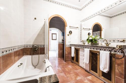 een badkamer met een bad, een douche en een wastafel bij Aumallia Hotel & Spa in Felanitx