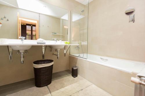 a bathroom with two sinks and a shower and a tub at Lux Apartments Barcelona in Barcelona