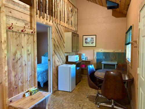 a small room with a desk and a table and chairs at Schott's Lake Conference & Resort in Sundre