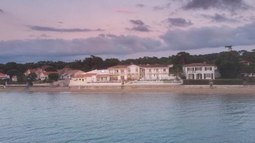 eine Gruppe von Häusern am Ufer des Wassers in der Unterkunft Beach Hotel - Le Grand Chalet in Ronce-les-Bains