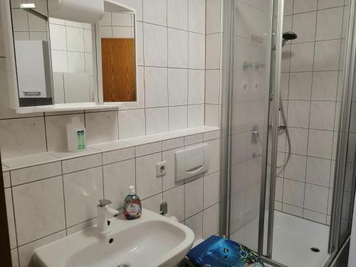 a white bathroom with a sink and a shower at Apartment Paradies in Öhringen
