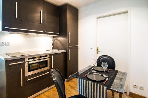 - une petite cuisine avec une table et des chaises dans l'établissement Un air de campagne en vieille ville - Proche lac, à Annecy