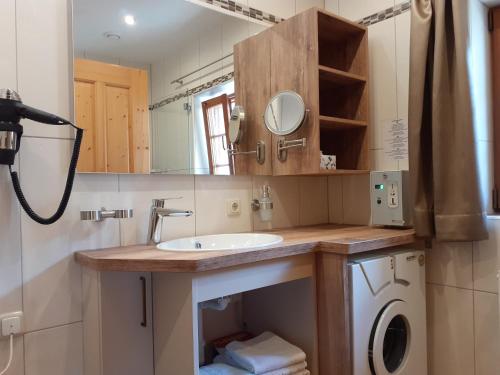 a bathroom with a sink and a washing machine at Ferienhaus Veider in Obertilliach