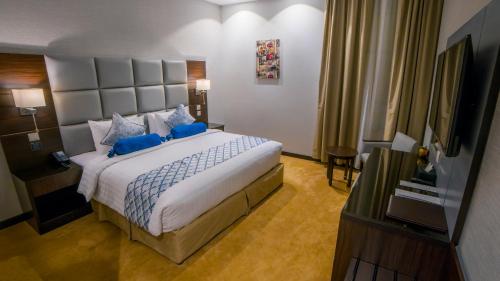 a bedroom with a large bed with blue pillows at Holiday Villa Hail in Hail