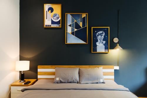1 dormitorio con 1 cama con 4 cuadros en la pared en Aimee House - Phan Bội Châu en Hanói