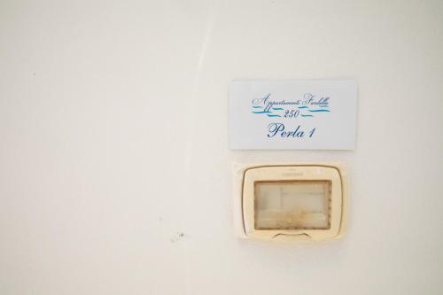 a white sign on a white wall with a box at Fardella 250 in Trapani