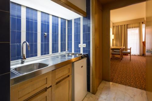 a kitchen with a sink and blue tiled walls at Hotel Estoril Eden in Estoril